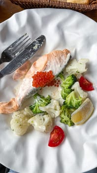 Savor this elegant salmon dish, featuring fresh vegetables and a touch of caviar. A delightful blend of flavors and presentation, perfect for a memorable dining experience.