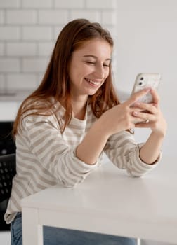 Happy Teen Girl Using Smartphone And Talking In Messenger