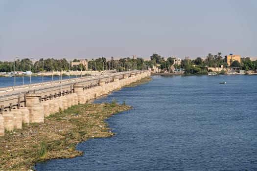 Old Esna dam and lock across the Nile River with sandy hills of Sahara desert behind