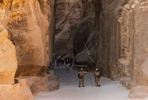 Petra, Jordan - 10 November 2024: Re-enactment soldiers stand guard at the narrow gorge of the Siq entering Petra in Jordan