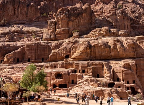 Petra, Jordan - 10 November 2024: Theater Necropolis in the Street of Facades in Petra with double Pylon tombs carved in the hillside