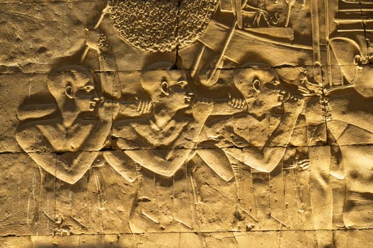 Detail of the carved images inside Edfu temple showing slaves carrying funeral boat and the many layers in bas-relief sculpture