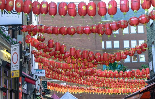 London, UK - May 13, 2025 - Beautiful of Red chinese lanterns hanging in rows above the street, strung between buildings, in London's Chinatown district, creating a festive and colorful atmosphere, use it as your Wallpaper, Poster and Space for text, Selective focus.