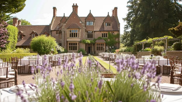 Elegant outdoor dining table set for a celebration in a beautiful garden with a historic building backdrop and purple lavender bushes.