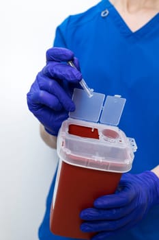 Doctor Disposes Needle, Ampule In Sharps Container. Disposal Container For Infectious Waste, Reducing Medical Waste Disposal. Small Medical Waste Plastic Box With Sharps For Bio Hazard. Vertical