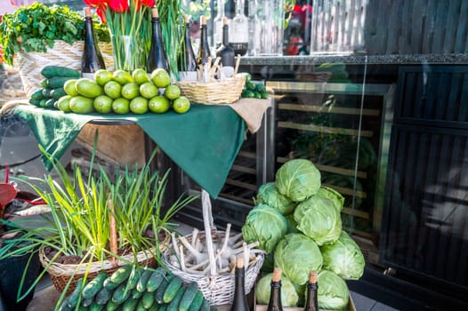 Street market stall with fresh vegetables. Cucumbers, young cabbage, garlic, parsley, wine, tulips, zucchini. The first harvest from the greenhouse on sale at the market from the farmer