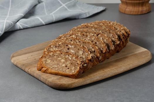 Sliced rye bread on cutting board. Whole grain rye bread with seeds.