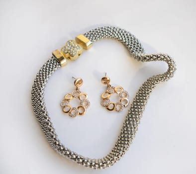Romantic jewelry set of sterling silver choker necklace and round chain earrings on white background.