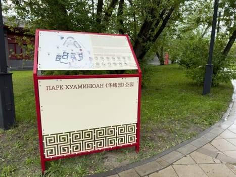 Moscow, Russia, April 25, 2025: Information stand with map and visitor rules at Huamin Park in Moscow features bilingual text in Russian and Chinese and decorative Asian style design