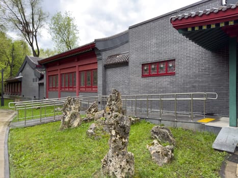 Moscow, Russia, April 25, 2025: Chinese style building in Huamin Park with modern accessibility features including ramp with metal railing and tactile tiles integrated into cultural environment