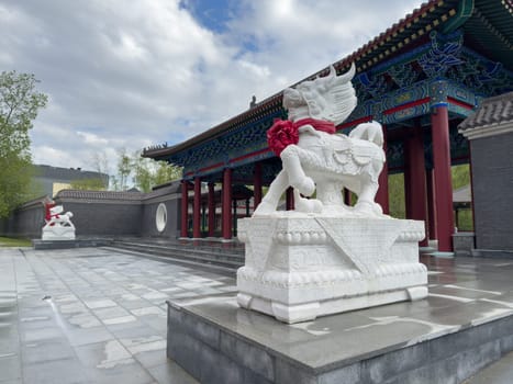 Moscow, Russia, April 25, 2025: Traditional Chinese arch with paired dragon statues at Huamin park entrance, representing cultural heritage and symbolic guardianship in urban Moscow setting