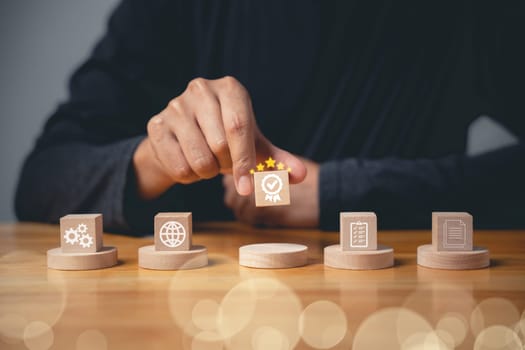 ISO certification concept displayed through smart globe icons with a check mark guarantee icon on a wooden cube. Hand flipping the ISO icons represents quality control management. Business technology