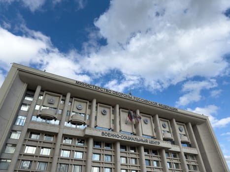Moscow, Russia, April 25, 2025: Military Social Center of Ministry of Defence of Russian Federation with official flags and emblems on concrete facade under blue sky in Moscow
