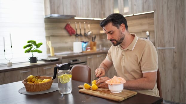 A man skillfully slices lemons to create a zesty treat in his kitchen.