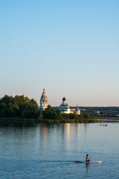 Vorsma, Nizhny Novgorod Region, Russia - 06.08.23. View of the Holy Trinity Ostrovoezersky Monastery with people on boats and SUPs.