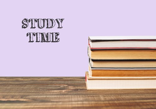 Stack of books with the word study time written on top. The books are piled on top of each other