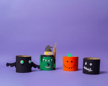 Group of Halloween decorations made from paper tubes. One of the tubes has a pumpkin on it