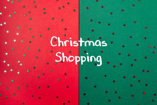 Red and green background with Christmas stars and the words Christmas shopping written on it. The stars are scattered all over the background