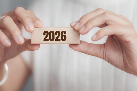 Female hand holding wooden block with 2026. Concept of new year, future planning, goals, resolution, timeline, and personal or business growth.