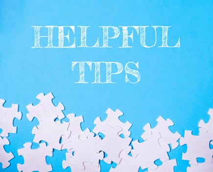 Blue background with white puzzle pieces and the words helpful tips written in white