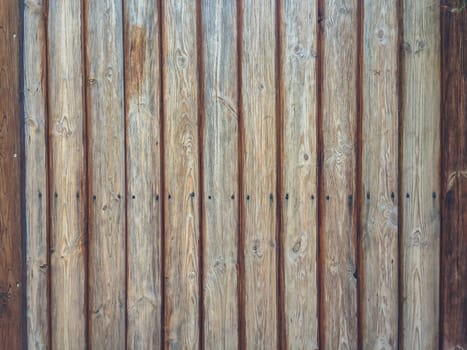 Wooden board with a grainy texture. The board is brown and has a few holes in it