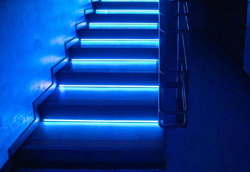 Abstract background with dark floor and blue neon light, empty scene for presentation or show of products. Glowing lights in the shape of a staircase.