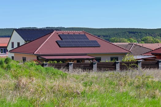 Family house with solar panels on the roof. Home photovoltaic power plant. Concept for industry and green cheaper electricity from renewable sources.