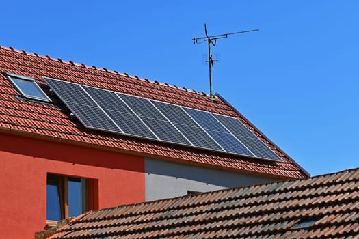 Family house with solar panels on the roof. Home photovoltaic power plant. Concept for industry and green cheaper electricity from renewable sources.
