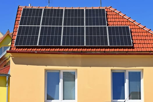 Family house with solar panels on the roof. Home photovoltaic power plant. Concept for industry and green cheaper electricity from renewable sources.