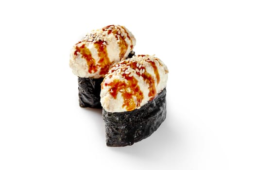 Two pieces of gunkan maki sushi are beautifully presented, topped with a creamy filling, sesame seeds, and a drizzle of unagi sauce