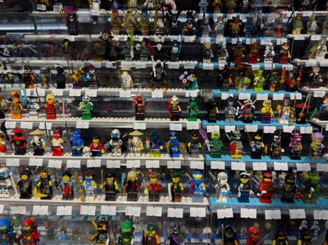 Moscow, Russia, April 25, 2025: Colorful display of collectible Lego mini figures in glass showcase at toy market, characters from popular franchises and fantasy series each tagged with prices
