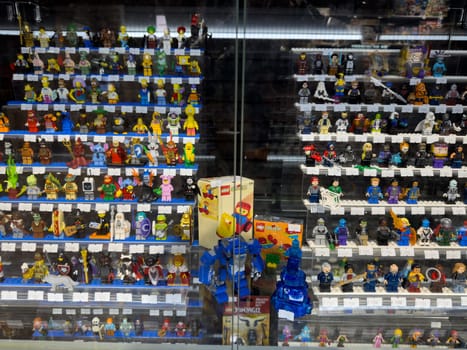 Moscow, Russia, April 25, 2025: Assorted Lego mini figures and rare collectible sets, including vintage Lego System boxes, displayed in glass showcase at toy collector stall in local market
