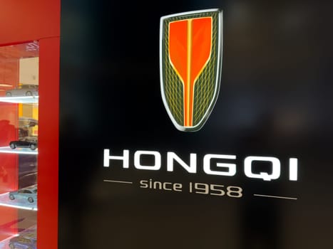 Moscow, Russia, April 25, 2025: Hongqi brand display with illuminated logo and model cars in showroom or retail space, showcasing luxury automotive heritage of Chinese manufacturer founded in 1958