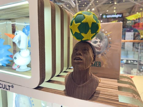 Moscow, Russia, April 25, 2025: Sculptural cardboard bust of a football player Ronaldinho balancing green and yellow ball on his head on display at 5CULT art store inside modern shopping center