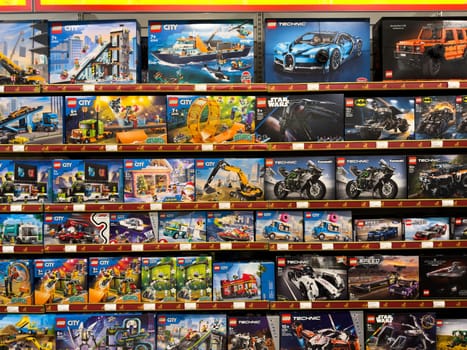 Moscow, Russia, April 25, 2025: Shelves filled with wide variety of LEGO sets including City, Technic, Star Wars, and Batman series inside large toy store in Moscow