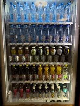 Moscow, Russia, April 25, 2025: Well stocked vending machine filled with bottled water, fruit juices, iced teas and soft drinks, offering convenient refreshment options for busy shoppers indoors