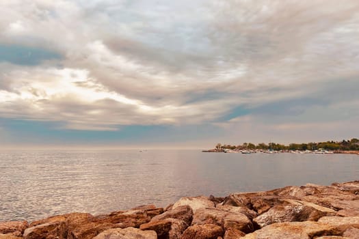 Sunrise and dramatic clouds. Early morning serene seascape in spring. Serene Spring Dawn.Witness the tranquil beauty of an early spring morning. The sun rises, casting a warm glow upon a calm sea, while dramatic clouds paint the sky, creating a breathtaking and serene seascape.
