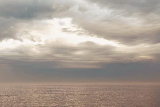 Sunrise and dramatic clouds. Early morning serene seascape in spring. Serene Spring Dawn.Witness the tranquil beauty of an early spring morning. The sun rises, casting a warm glow upon a calm sea, while dramatic clouds paint the sky, creating a breathtaking and serene seascape.
