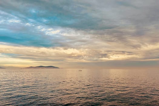 Sunrise and dramatic clouds. Early morning serene seascape in spring. Serene Spring Dawn.Witness the tranquil beauty of an early spring morning. The sun rises, casting a warm glow upon a calm sea, while dramatic clouds paint the sky, creating a breathtaking and serene seascape.