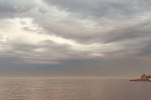 Sunrise and dramatic clouds. Early morning serene seascape in spring. Serene Spring Dawn.Witness the tranquil beauty of an early spring morning. The sun rises, casting a warm glow upon a calm sea, while dramatic clouds paint the sky, creating a breathtaking and serene seascape.