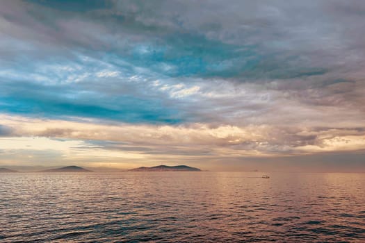 Sunrise and dramatic clouds. Early morning serene seascape in spring. Serene Spring Dawn.Witness the tranquil beauty of an early spring morning. The sun rises, casting a warm glow upon a calm sea, while dramatic clouds paint the sky, creating a breathtaking and serene seascape.