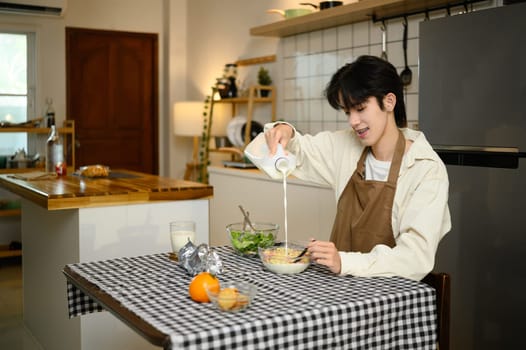 Young asian man enjoying healthy breakfast at home.