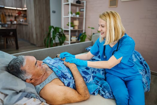 Nurse gently attends to an elderly man in his home.