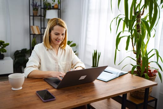 A woman enjoys productive time at her home desk.