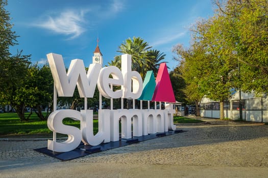 Nov 6, 2024 - Lisbon, Portugal: Big Web Summit sign displayed outdoors in park with lush palm trees on sunny day clear blue skies. Major technology conference,internet technology, emerging technology, marketing, AI solution, spirit of innovation