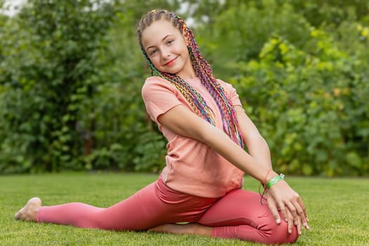Girl is in a gymnastic pose smiling at the camera. Horizontally. 