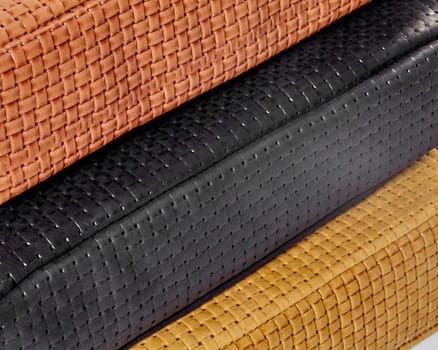 Close-up of stacked woven leather samples in various colors, highlighting texture and craftsmanship