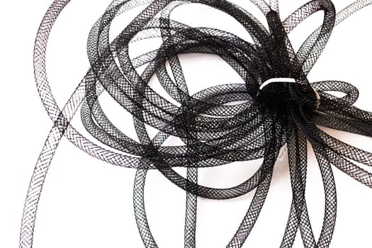 A collection of elegant black ribbons is scattered across a pristine white surface, creating a striking visual contrast