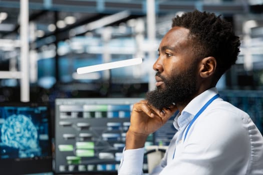 Data center workplace technician using artificial intelligence neural networks technology. Server hub specialist using AI programming language on computer, configuring specialized hardware