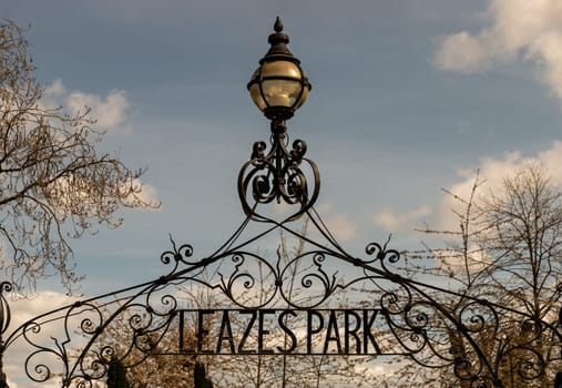 Newcastle, UK - Apr 13, 2025 - View of Cast iron lamp over the Wrought iron gate is open to the entrance of Leazes park with beautiful sky background. use it as your Wallpaper, Poster and Space for text, Selective focus.